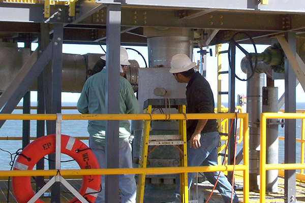 Two AIMS workers installing custom platform on an offshore oil platform